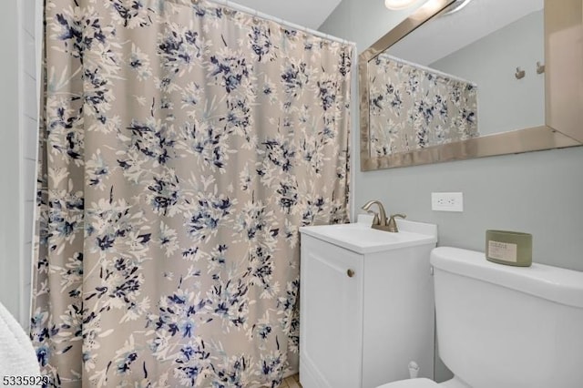 bathroom with vanity, toilet, and curtained shower