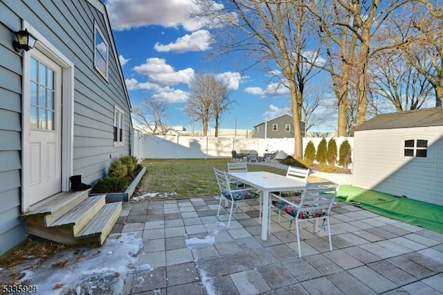 snow covered patio featuring a storage unit