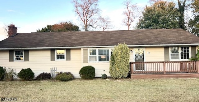 view of front facade with a wooden deck and a front lawn