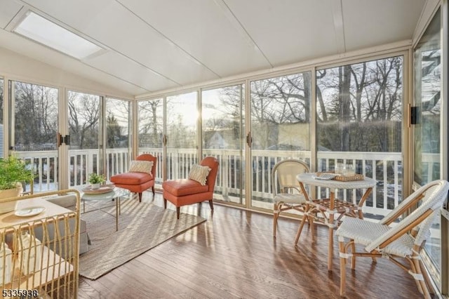 sunroom / solarium featuring plenty of natural light and vaulted ceiling with skylight