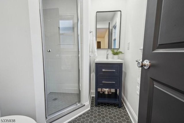 bathroom with a shower with door, vanity, and tile patterned flooring