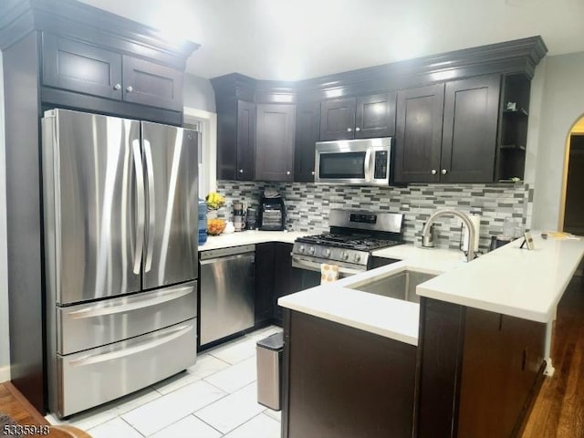 kitchen featuring appliances with stainless steel finishes, a breakfast bar, tasteful backsplash, sink, and kitchen peninsula