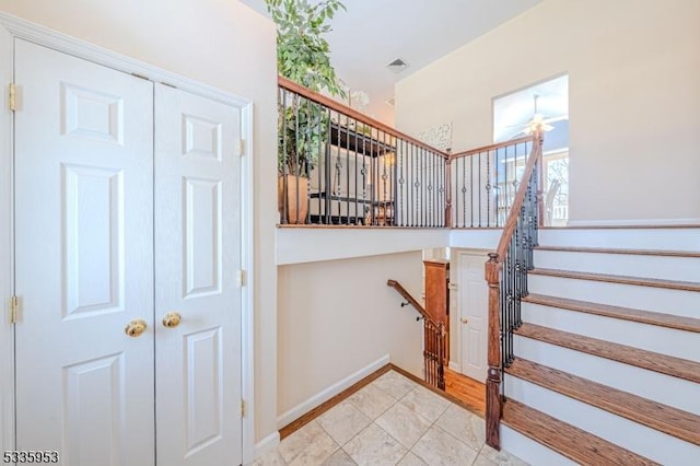 staircase with ceiling fan and tile patterned floors