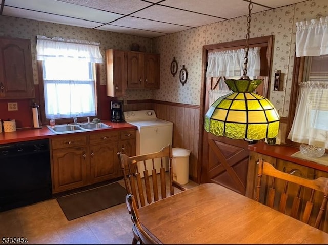 kitchen featuring a drop ceiling, dishwasher, sink, and washer / dryer