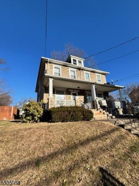 view of front of property with a porch and a front yard