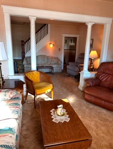 carpeted living room featuring decorative columns