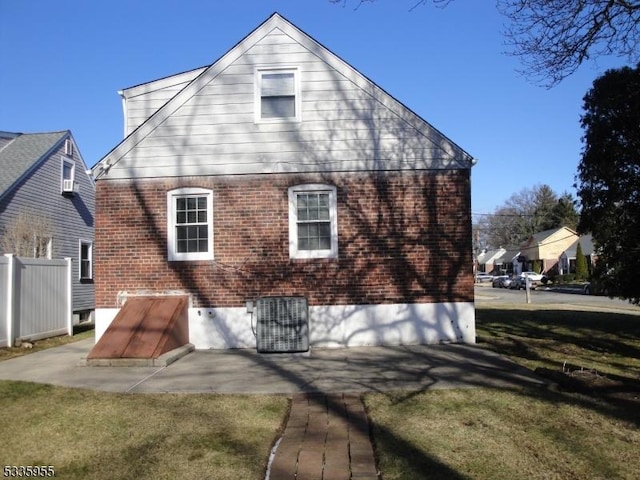 back of house with a patio area and a lawn