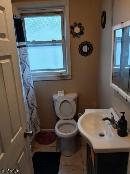 bathroom featuring vanity, tile patterned floors, and toilet