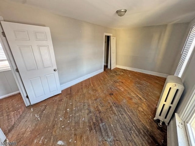 spare room featuring hardwood / wood-style floors and baseboards