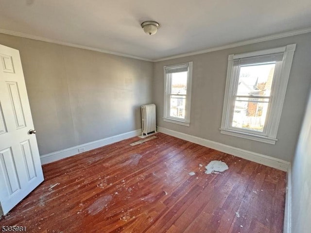 unfurnished room with baseboards, crown molding, radiator heating unit, and hardwood / wood-style flooring