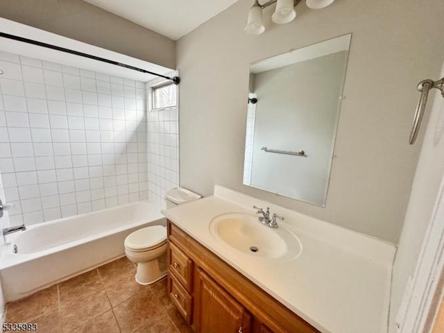 full bathroom featuring vanity, tiled shower / bath, tile patterned floors, and toilet