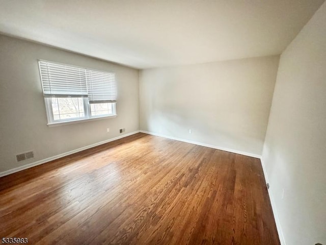 unfurnished room with wood-type flooring