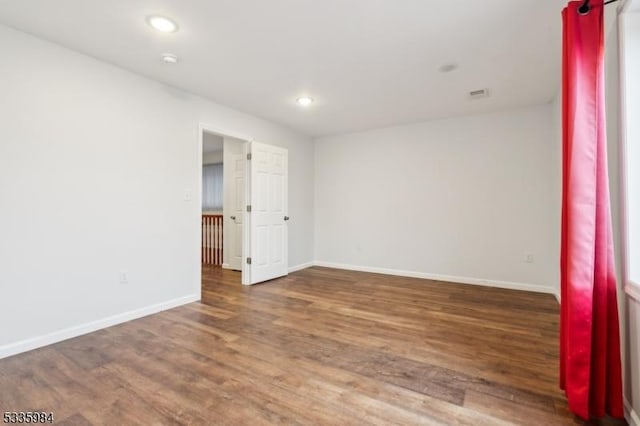 empty room featuring recessed lighting, wood finished floors, visible vents, and baseboards