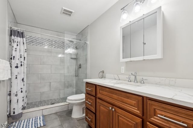 full bathroom with visible vents, toilet, a tile shower, vanity, and tile patterned floors