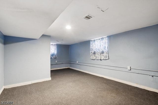 below grade area with baseboards, visible vents, and carpet flooring