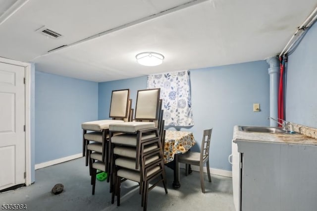 dining room featuring concrete flooring, visible vents, and baseboards