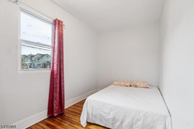 bedroom with baseboards and wood finished floors