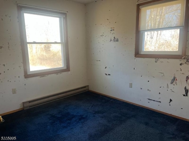 carpeted spare room with a baseboard radiator and a healthy amount of sunlight