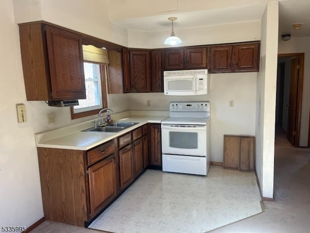 kitchen featuring pendant lighting, white appliances, and sink