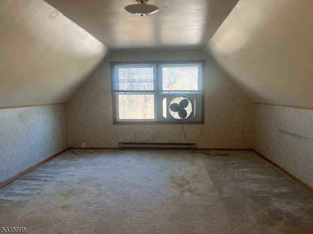 additional living space with a baseboard heating unit, vaulted ceiling, and carpet flooring