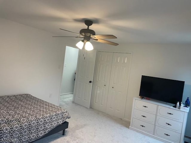 carpeted bedroom featuring ceiling fan and a closet