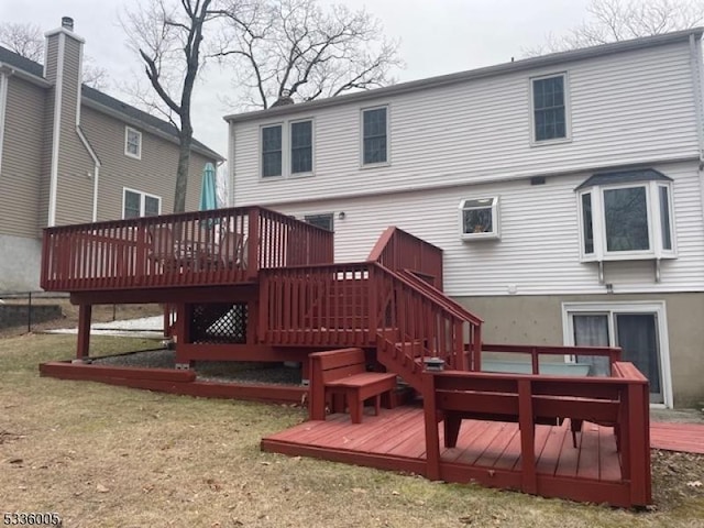 rear view of house with a wooden deck and a yard