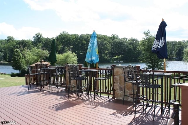 deck featuring a water view and exterior bar