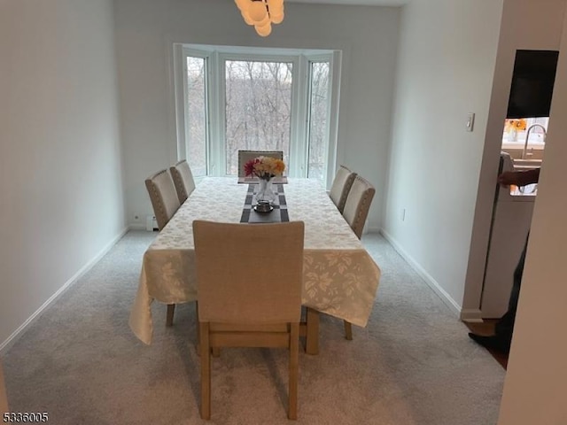 dining room featuring sink and light carpet