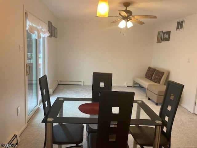 carpeted dining space with ceiling fan and baseboard heating