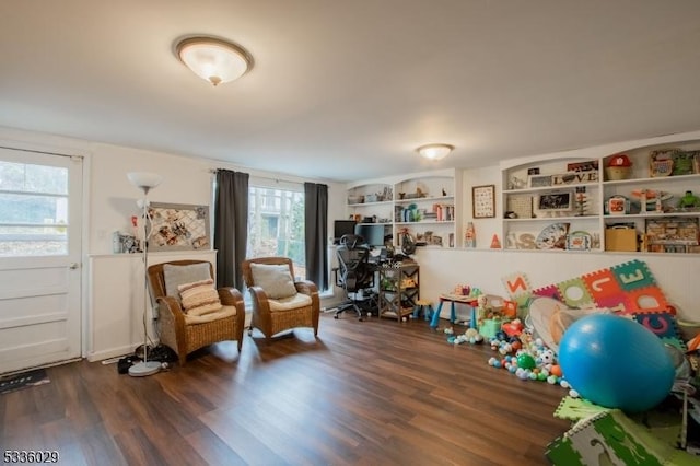 recreation room with built in shelves and dark wood-type flooring