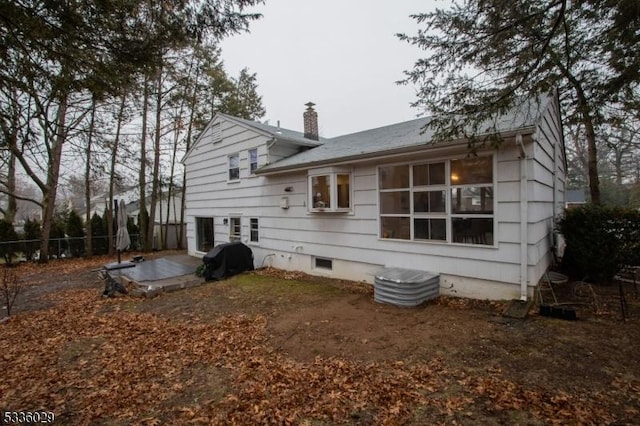 rear view of house with a patio area, a chimney, and fence