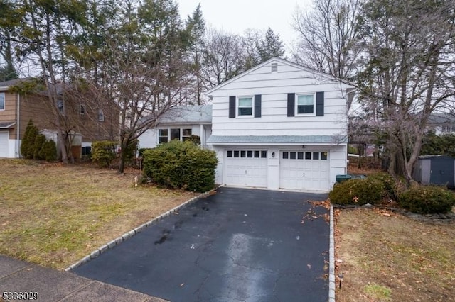 view of front of house with a garage, a front yard, and driveway