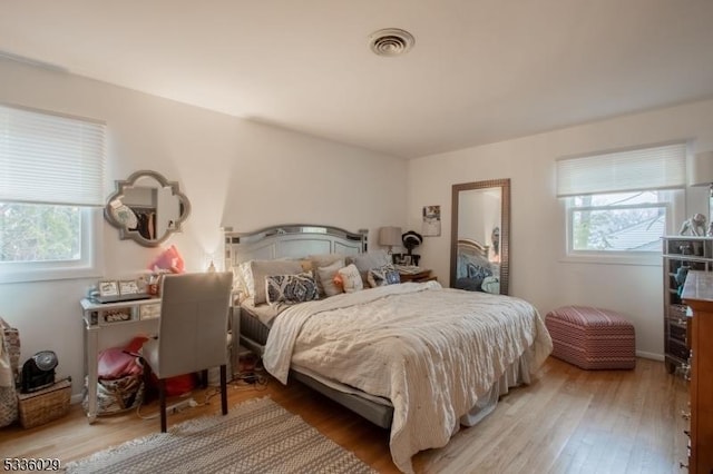 bedroom featuring visible vents and wood finished floors