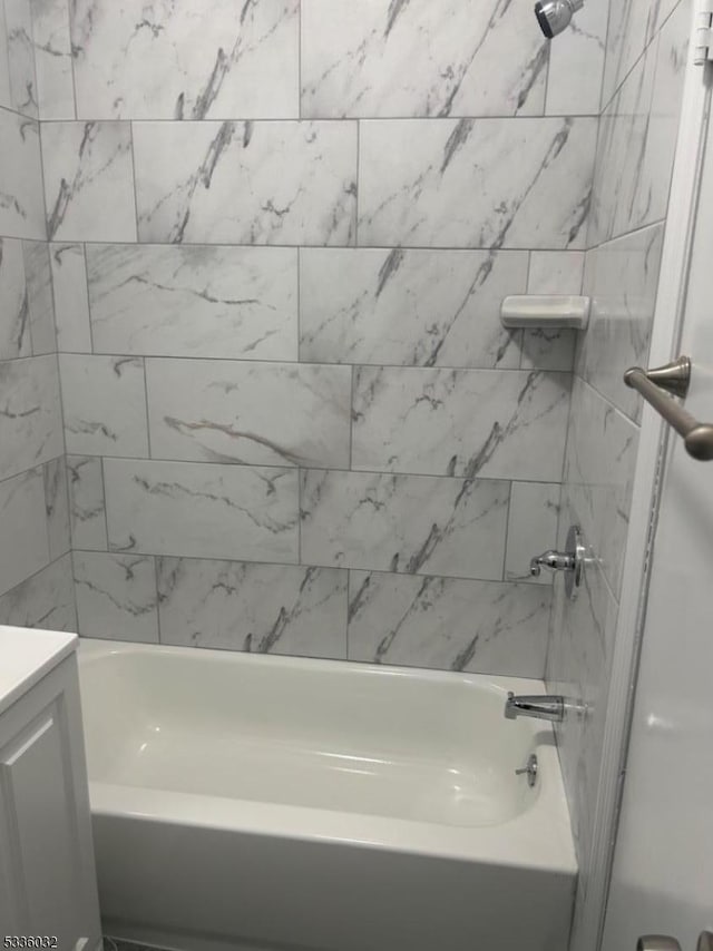 bathroom featuring vanity and tiled shower / bath