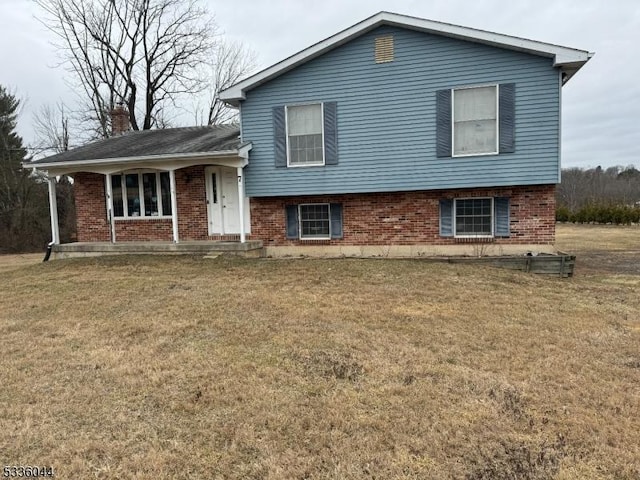 tri-level home with covered porch and a front lawn