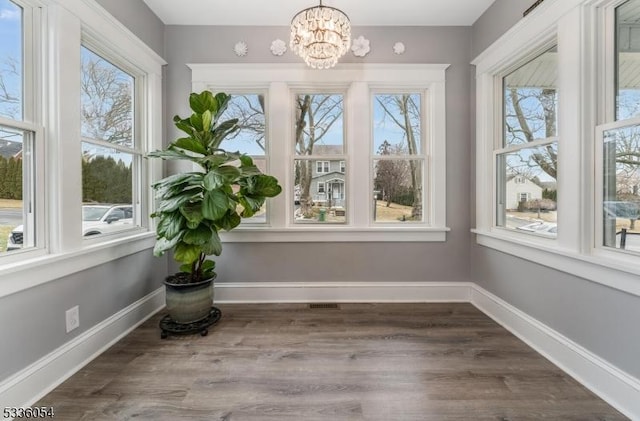 unfurnished sunroom with a notable chandelier