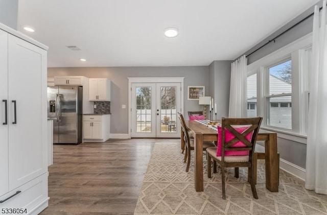 dining room with wood-type flooring and french doors