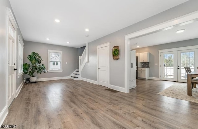 interior space featuring french doors, a healthy amount of sunlight, and hardwood / wood-style floors