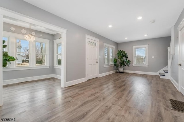 foyer with a notable chandelier and wood-type flooring