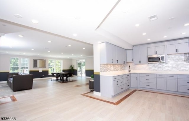 kitchen with a wealth of natural light, gray cabinetry, and backsplash