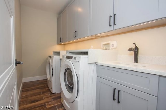 laundry area with cabinets, washing machine and dryer, and sink