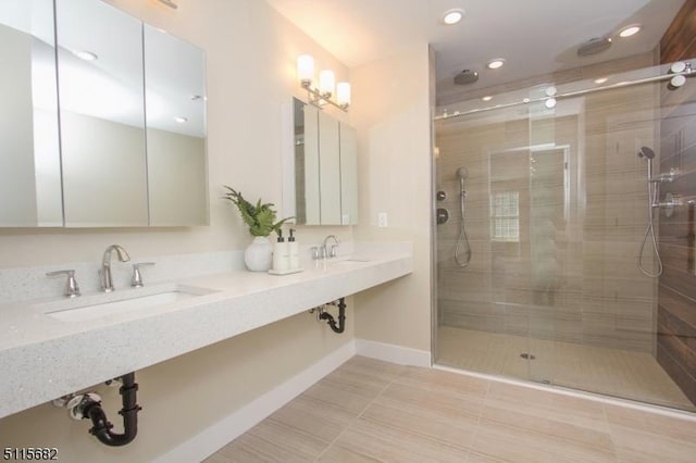 bathroom featuring sink, a shower with shower door, and tile patterned floors