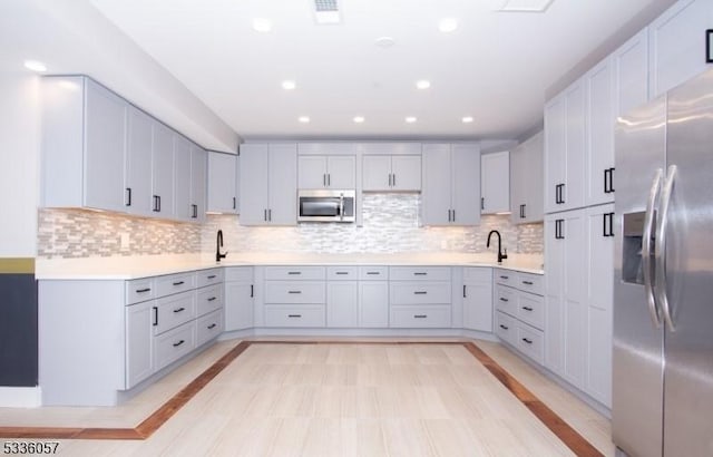 kitchen featuring appliances with stainless steel finishes, sink, and decorative backsplash