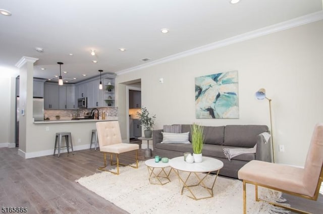 living room with crown molding and light hardwood / wood-style floors