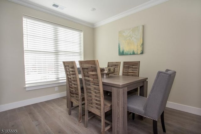 dining area featuring wood-type flooring and ornamental molding