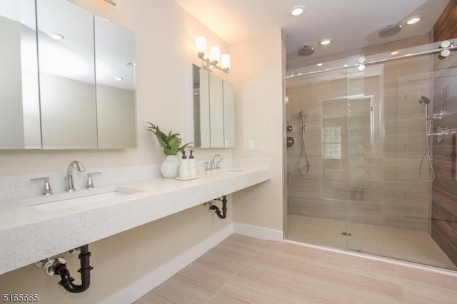 bathroom featuring sink, an enclosed shower, and tile patterned floors