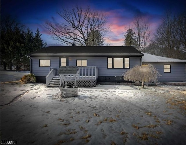 snow covered rear of property featuring a wooden deck