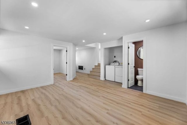 basement with washer and dryer and light wood-type flooring