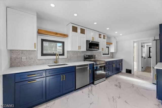 kitchen featuring sink, white cabinets, decorative backsplash, stainless steel appliances, and blue cabinetry