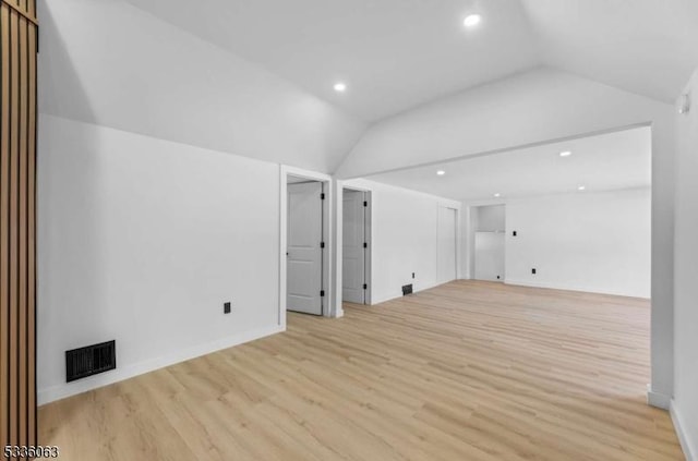 unfurnished living room featuring lofted ceiling and light hardwood / wood-style floors